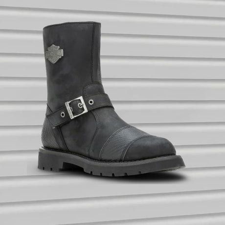 Black leather Harley Davidson boot with a silver buckle on a gray background