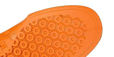 Close-up of an orange shoe sole with a hexagonal pattern