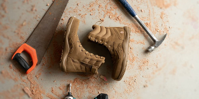 Tan tactical work boots with side zipper on a dusty floor—tactical work boots collection